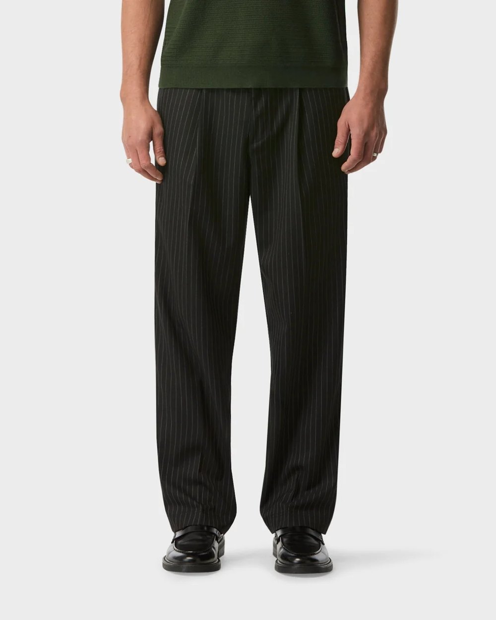 Black pinstripe pleated tailored pant worn with black loafers
