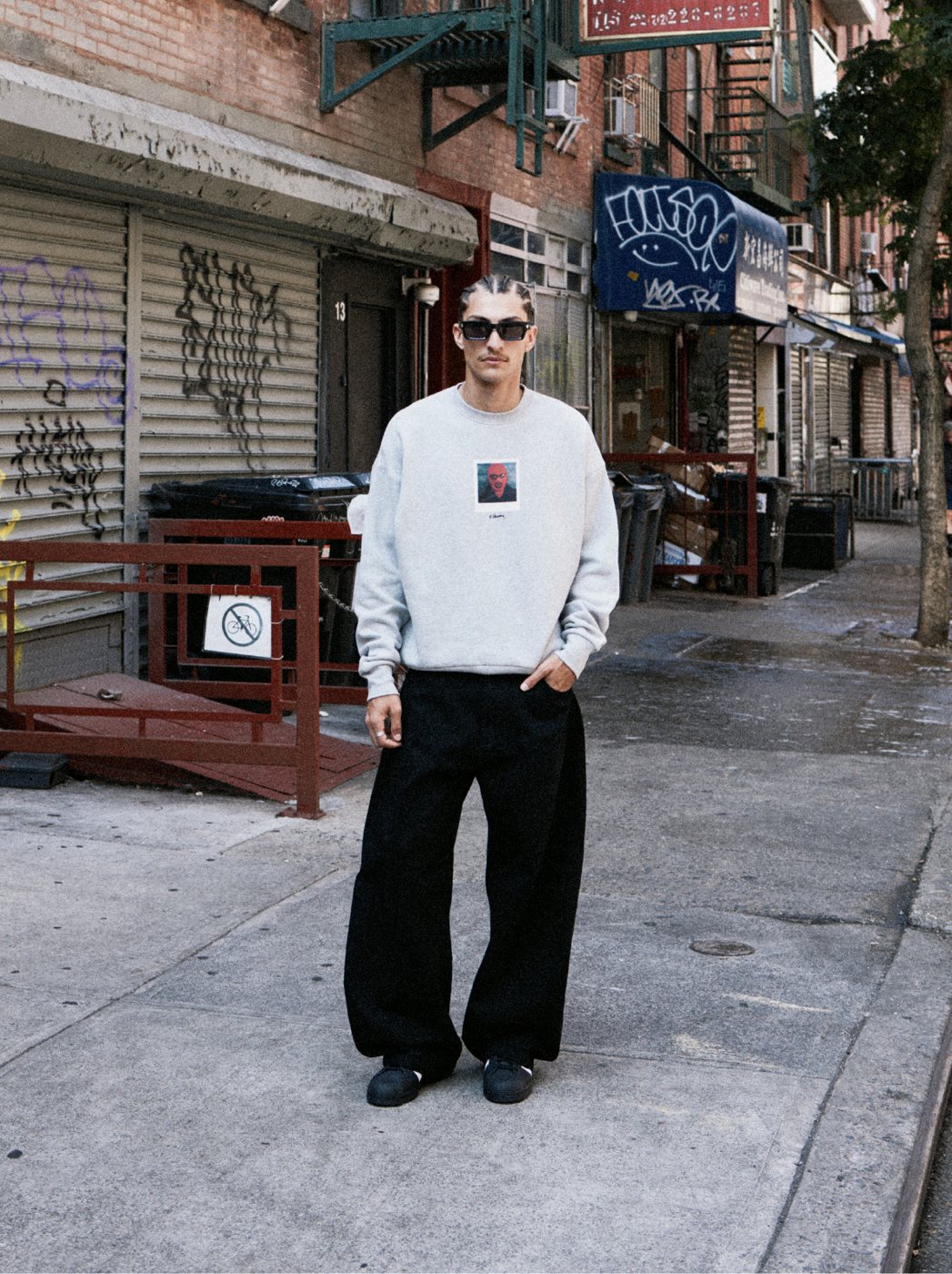 I Love Ugly x Keith Haring: Grey graphic crewneck and black wide-leg pants on a New York street