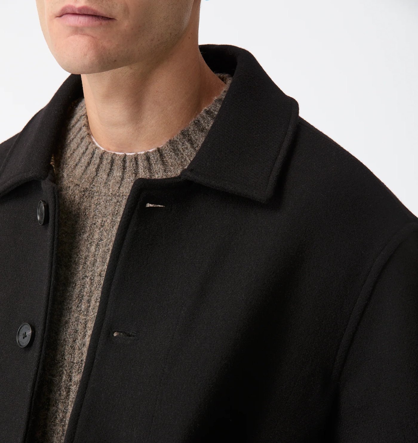 Close-up of the melton collar, engraved buttons and knit layered underneath