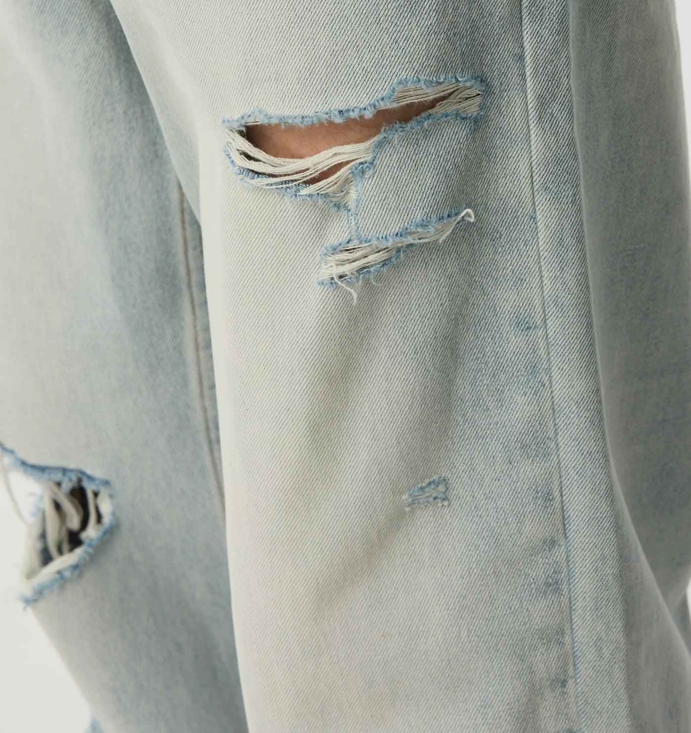 Close-up of the hand distressed rips and bleached twill