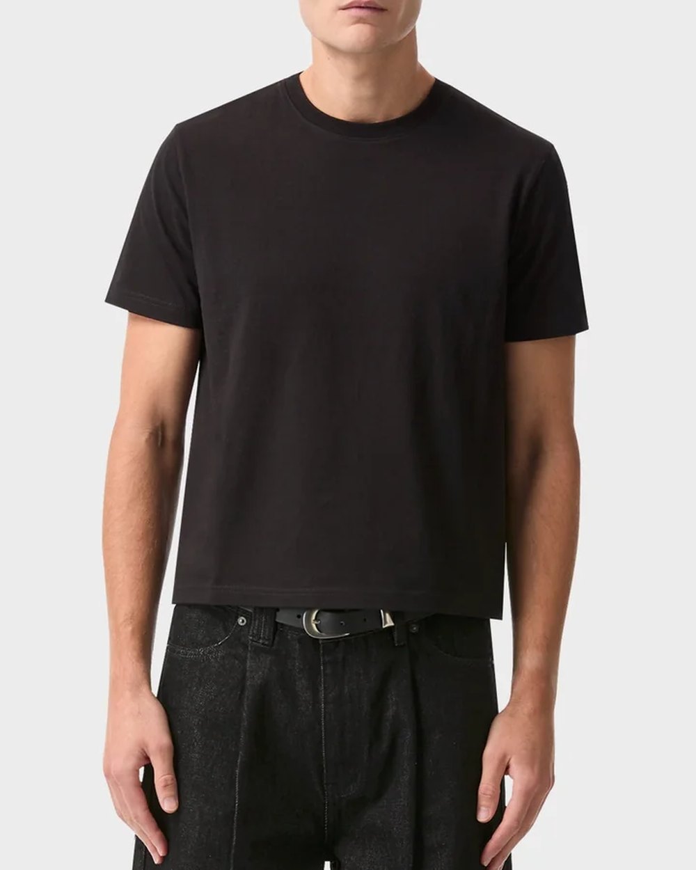 Black muscle tee worn with raw black denim
