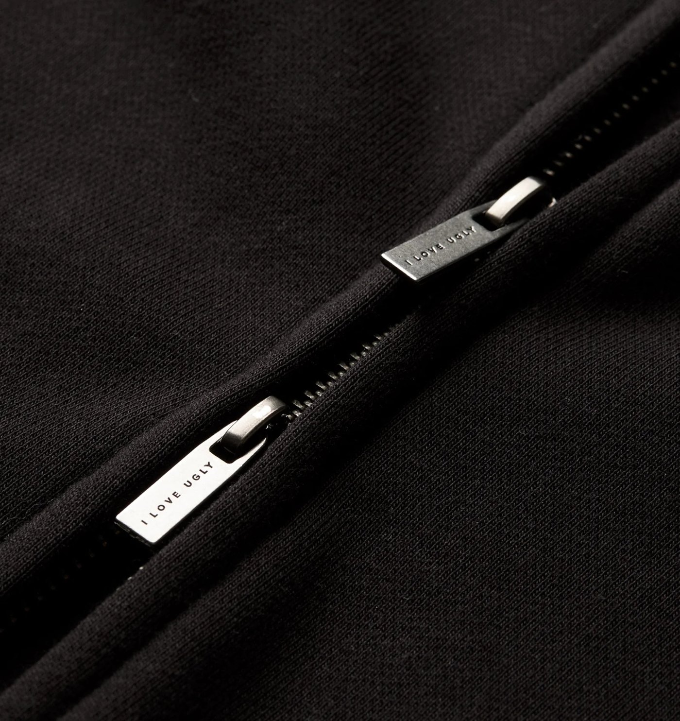 Close-up of the two-way zip with branded metal pullers
