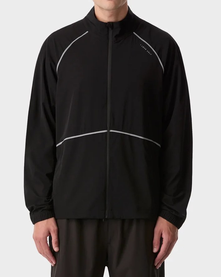 Black funnel neck windbreaker with reflective piping across the chest and raglan seams