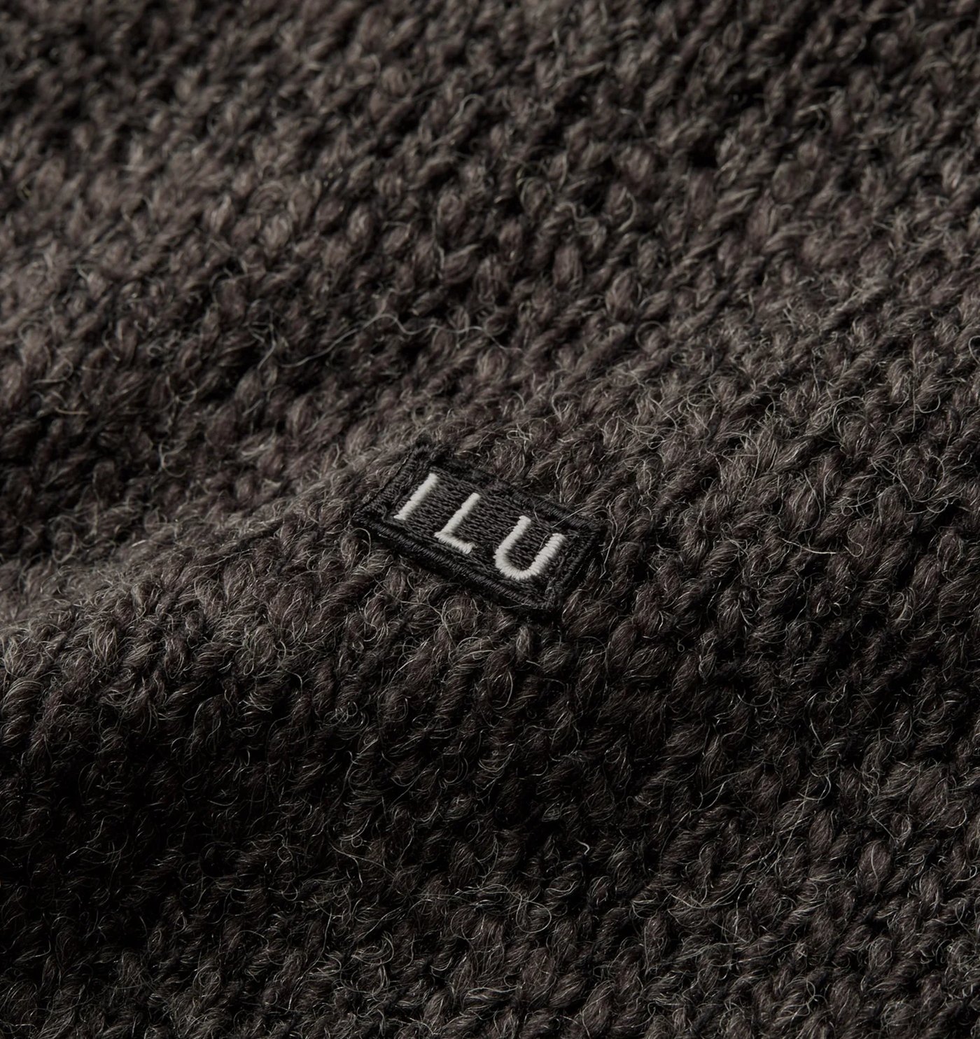 Close-up of the brushed marl knit and embroidered ILU chest badge