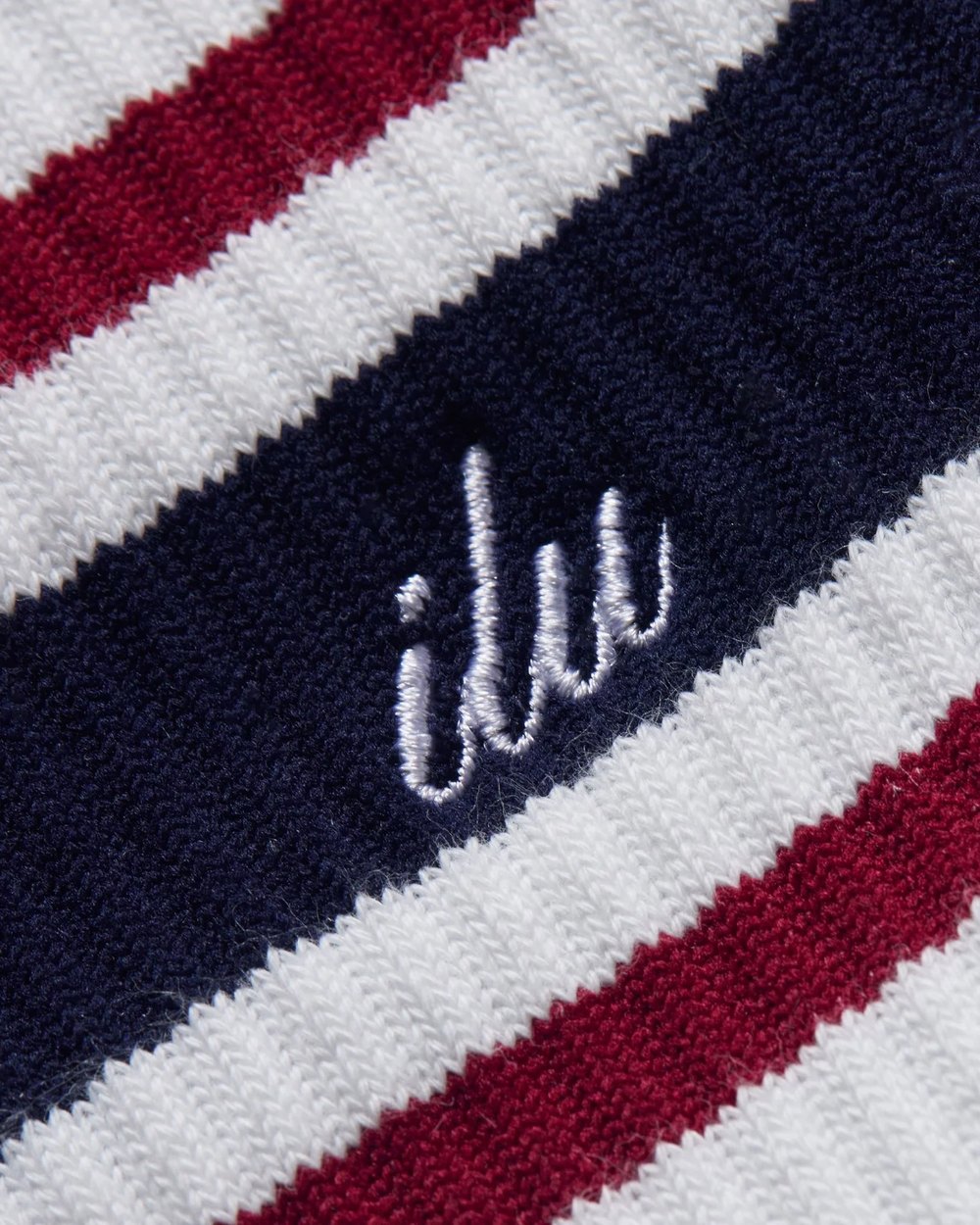 Close up of the embroidered ilu script on the navy stripe