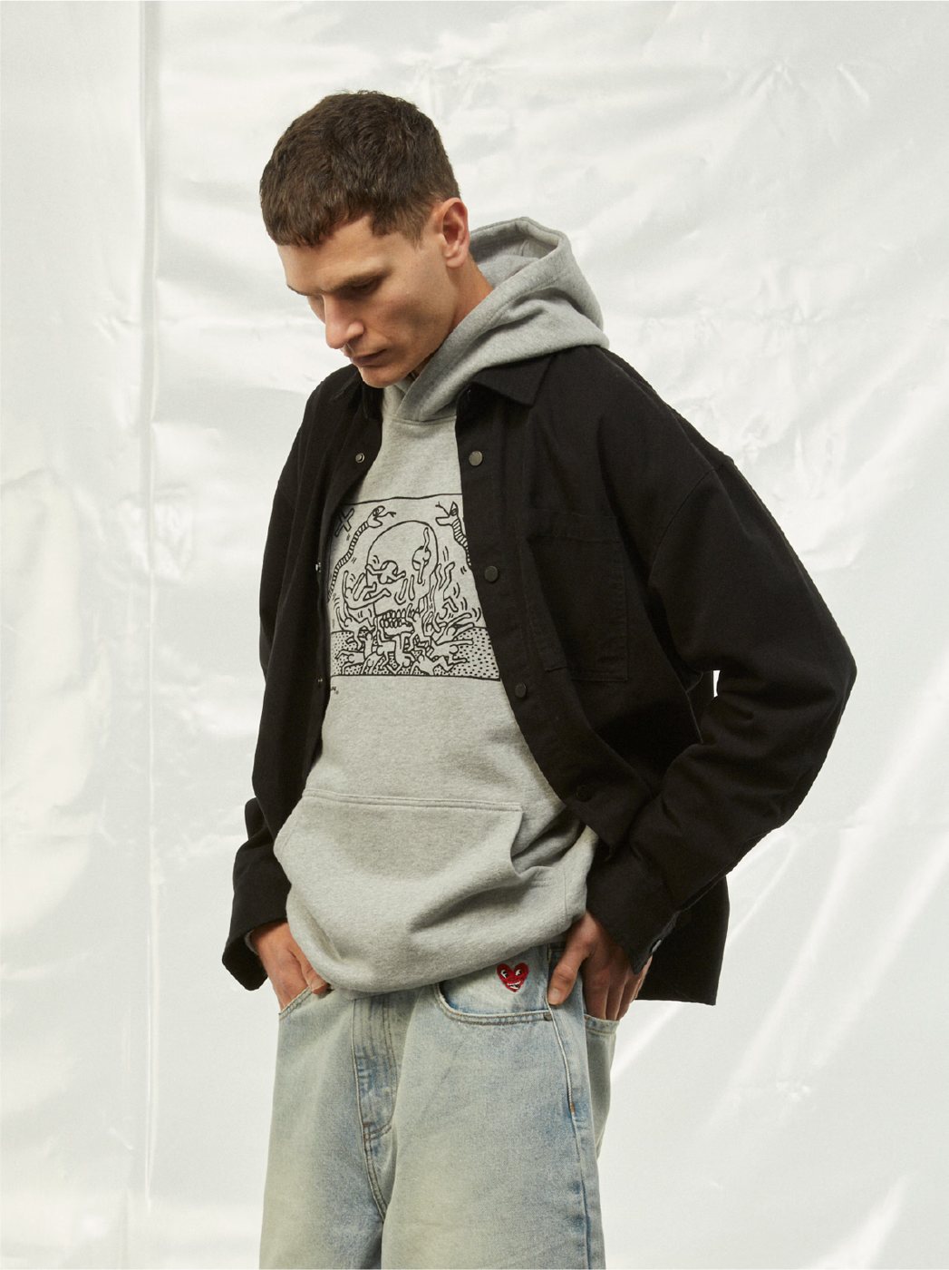 I Love Ugly x Keith Haring: Grey Keith Haring hoodie under a black jacket