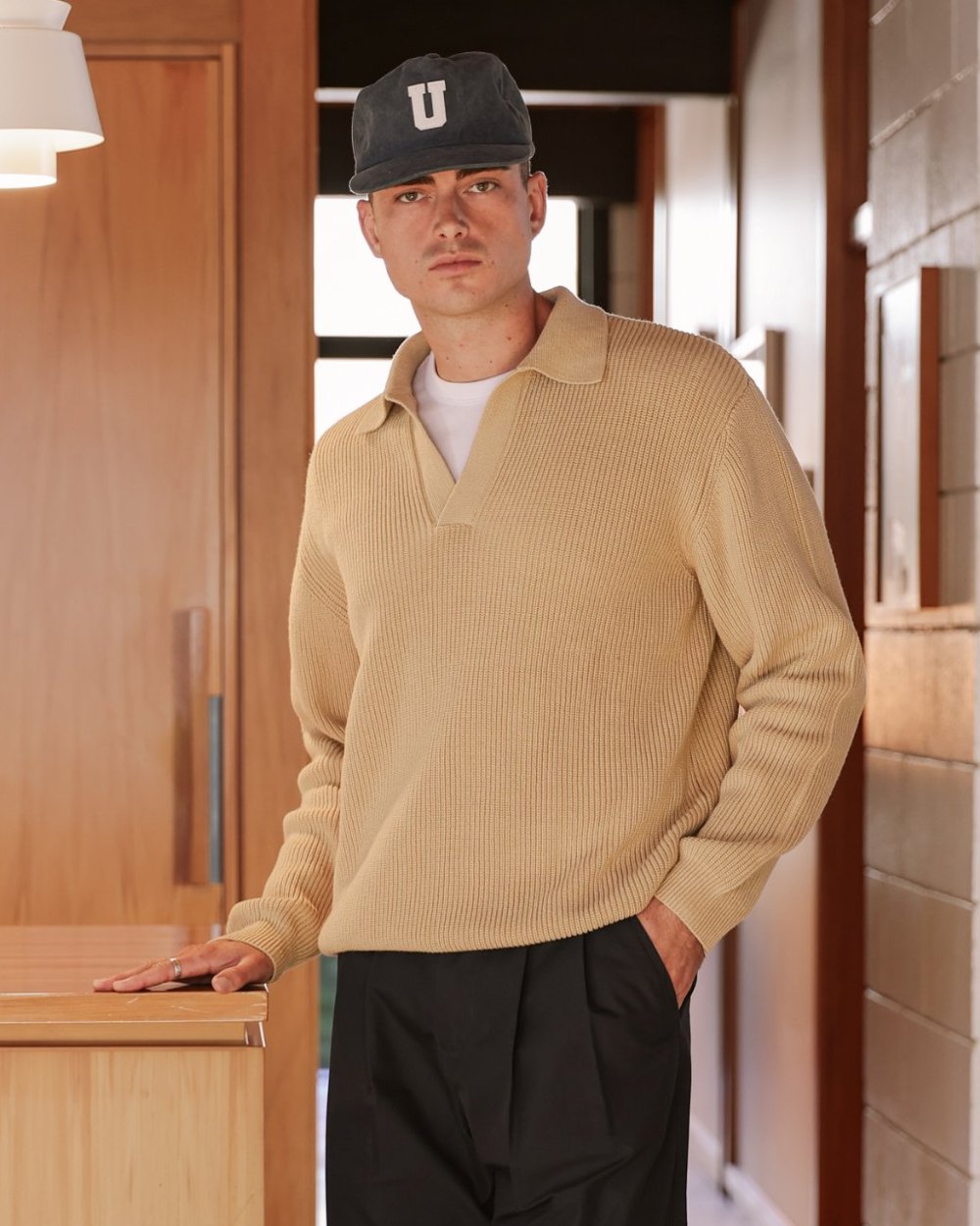 Sand ribbed knit polo with open collar worn over a white tee
