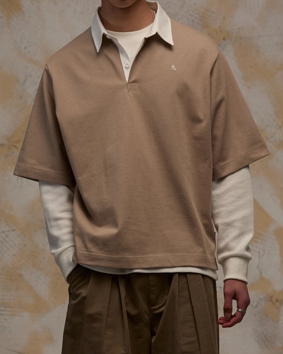 Tan short sleeve rugby polo with contrast white collar, layered over a waffle long sleeve