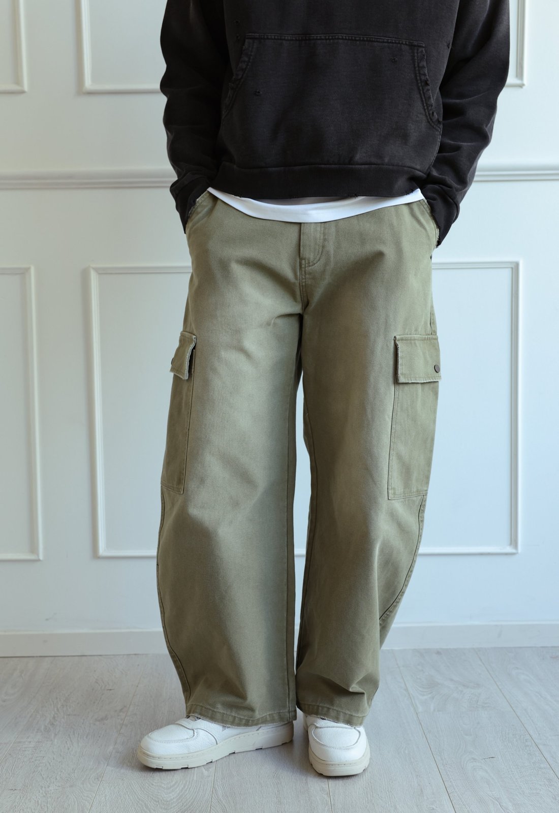 Olive heavyweight canvas balloon cargo pants with flap cargo pockets, worn with white sneakers