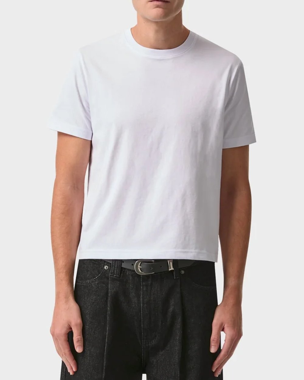 White fitted muscle tee worn with raw black denim