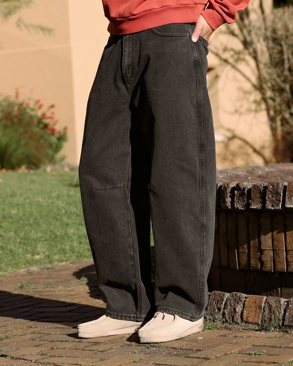 Washed black barrel leg jeans with knee seams worn with sand suede shoes