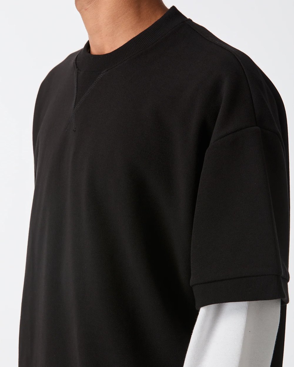 Close up of the cuff tee V stitch neckline and ribbed sleeve cuff