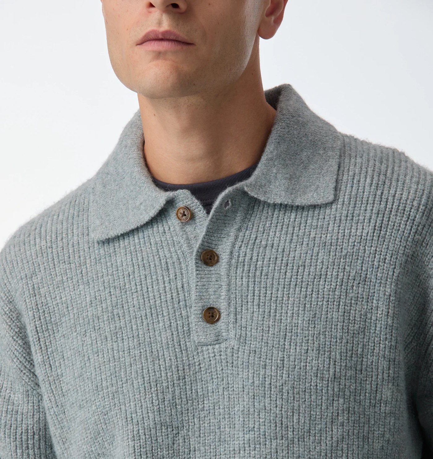 Close-up of the knit polo collar and horn-look placket buttons