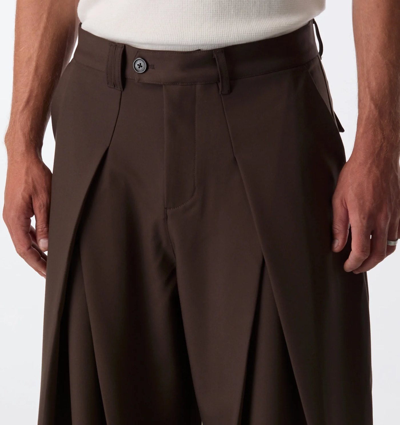 Close-up of the waistband, engraved button and deep front pleats