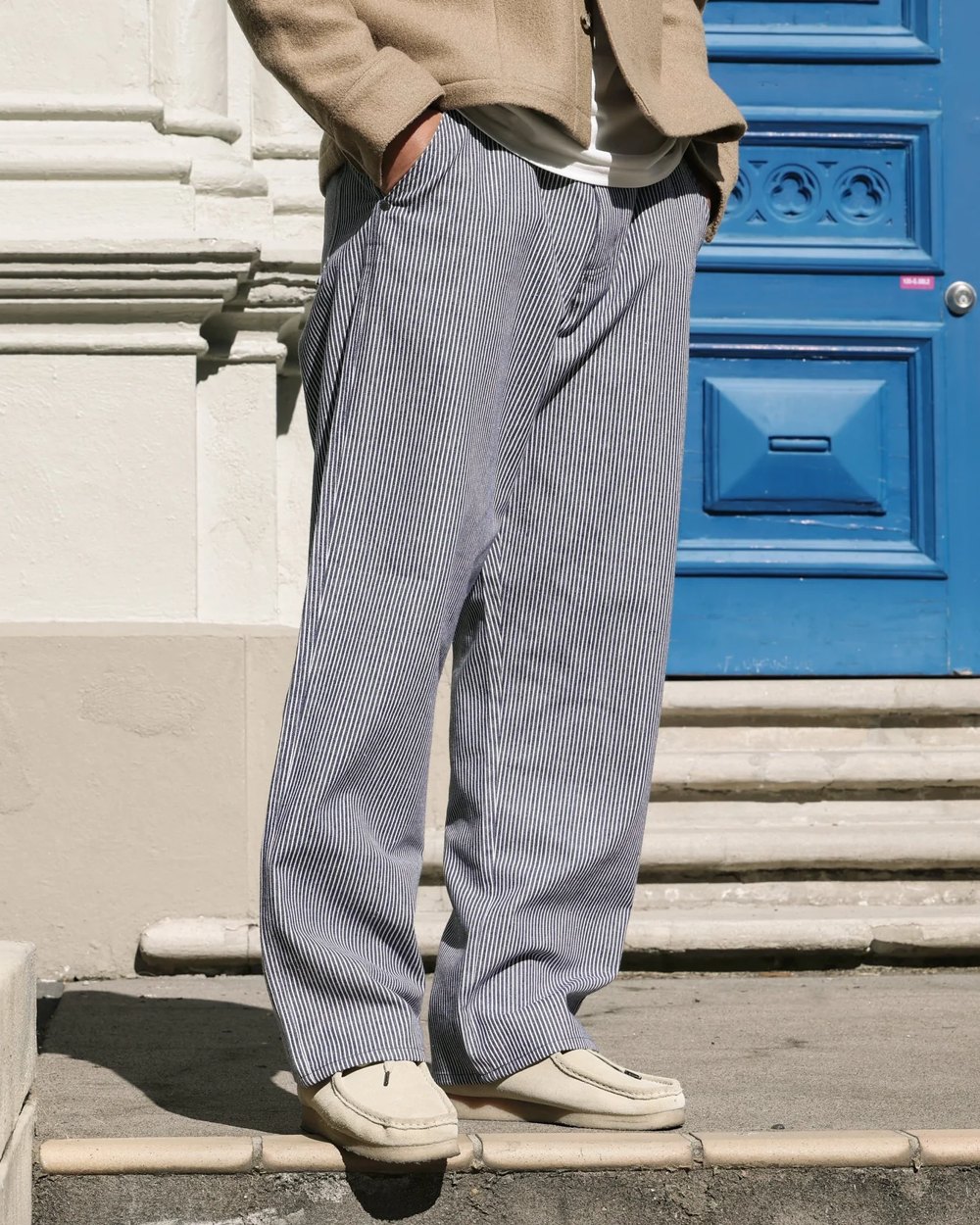 Navy and white hickory stripe workwear pant worn with sand suede shoes