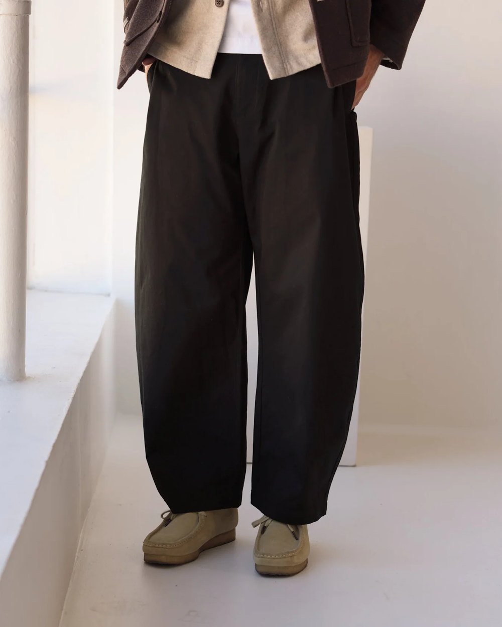 Black barrel leg pant worn with sand suede shoes