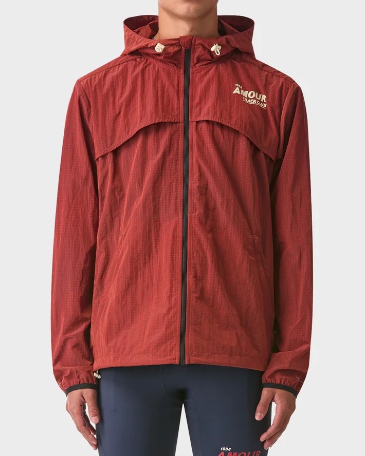 Front of the rust Track Club windbreaker with chest print and toggle hood