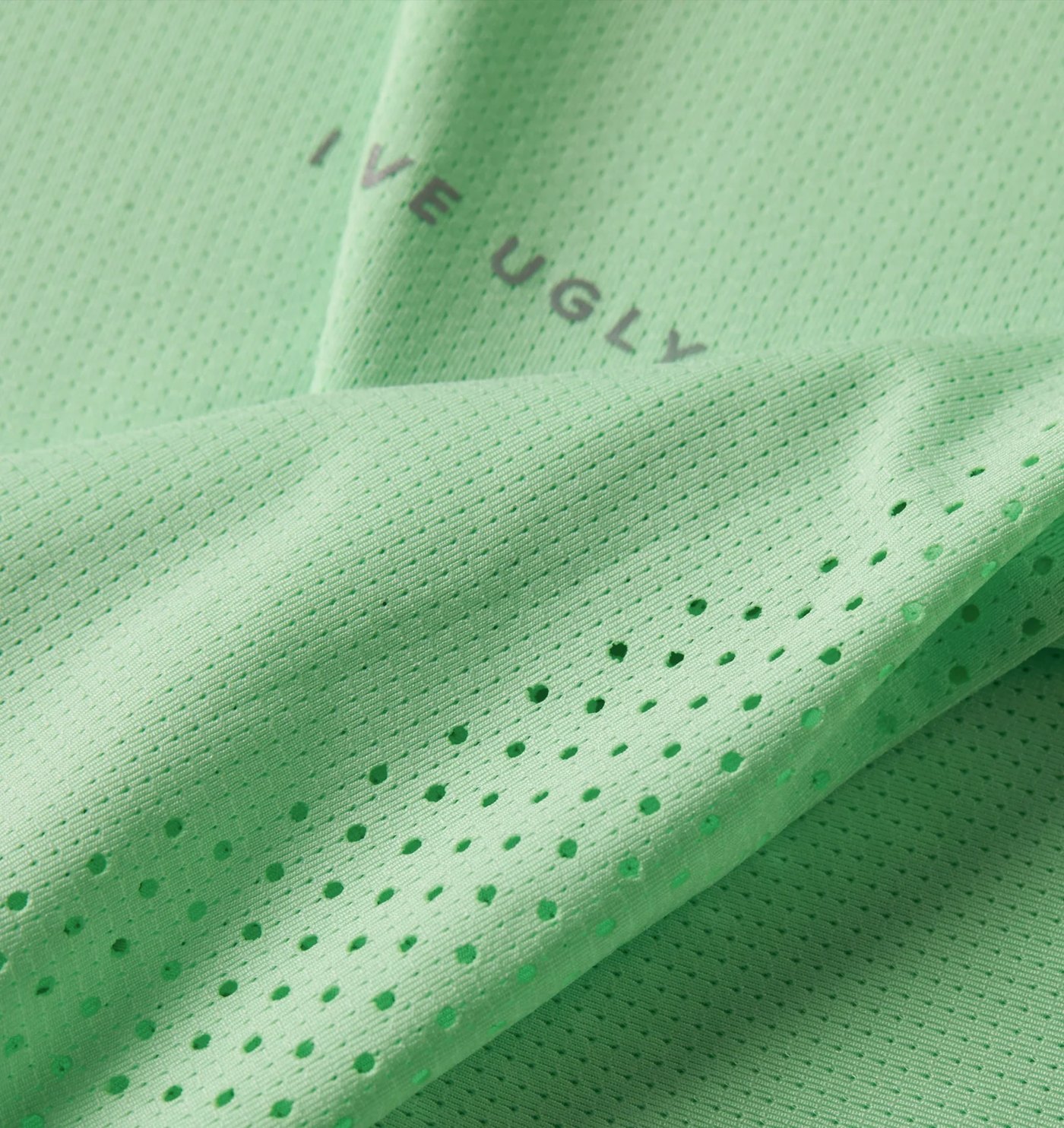 Close-up of the mint micro-mesh, laser perforation and reflective wordmark