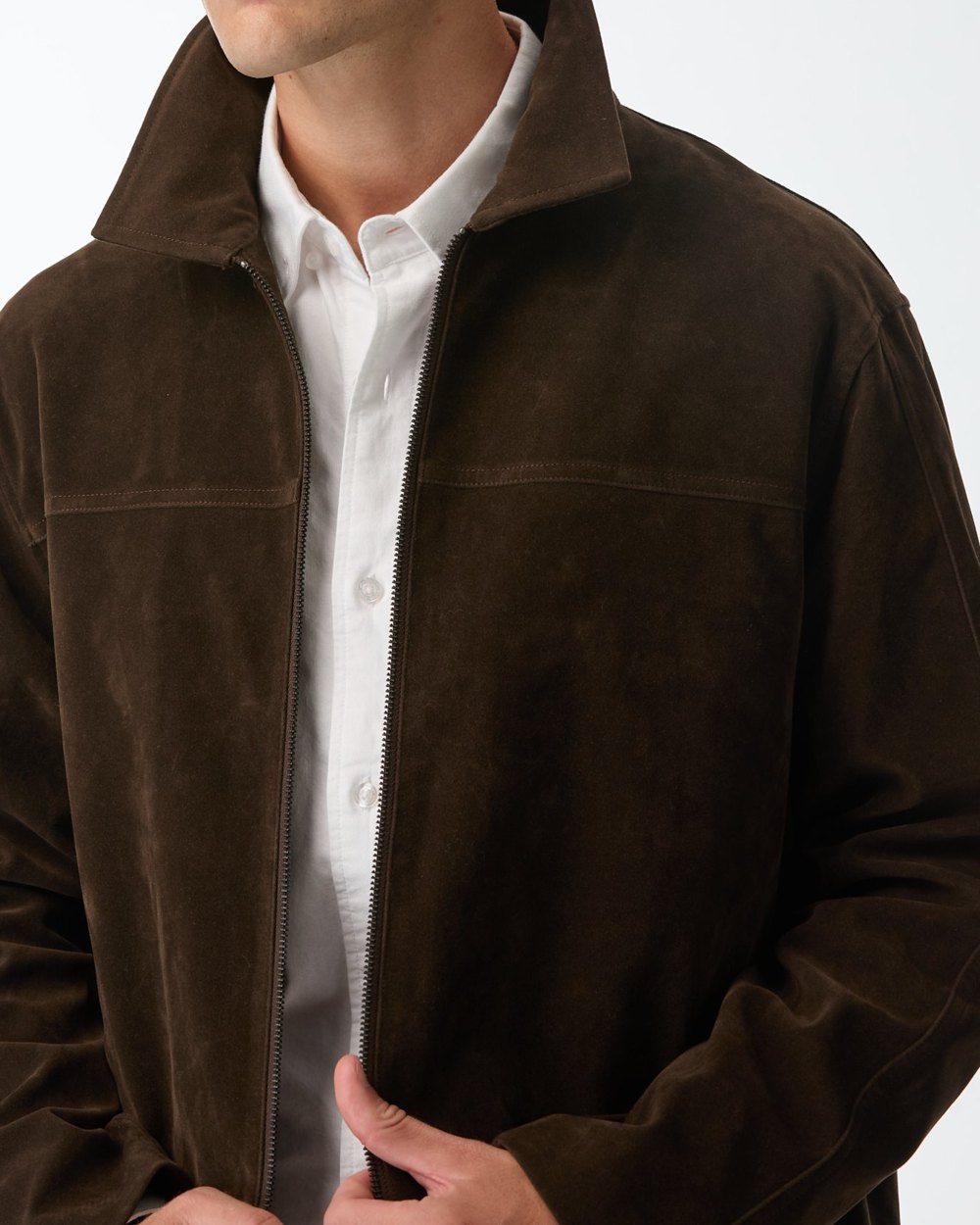 Suede zip jacket worn open over a white oxford shirt