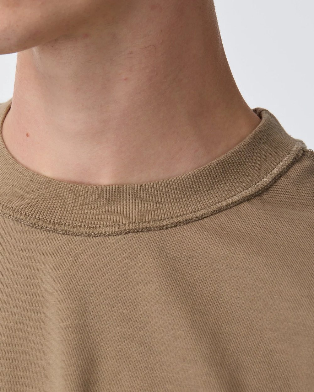 Close up of the crop box tee ribbed neckband and raw edge stitching