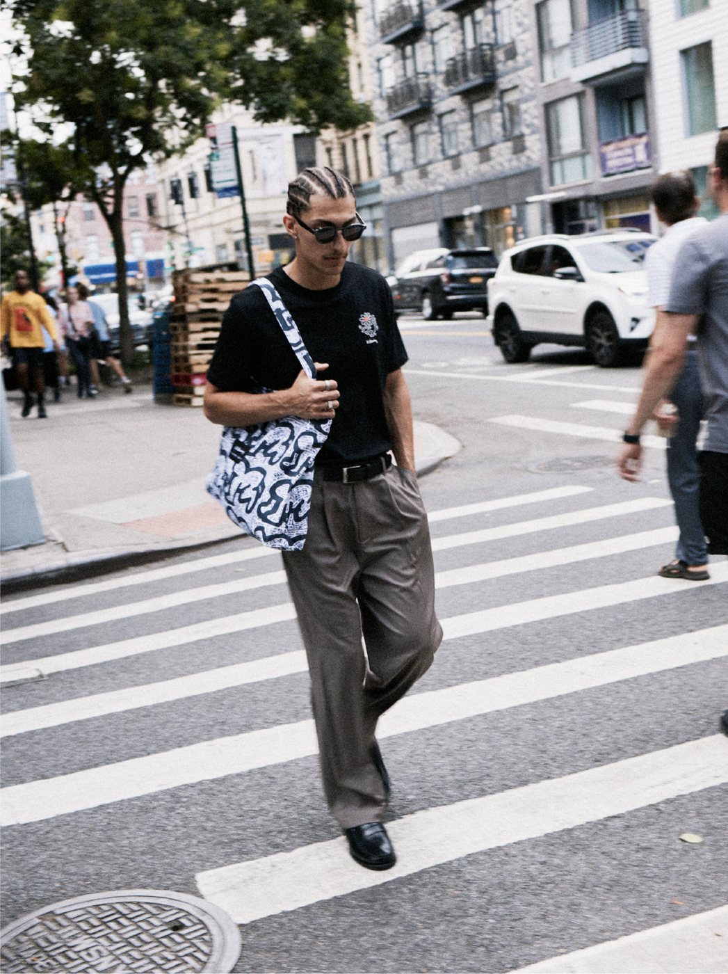I Love Ugly x Keith Haring: Black graphic tee and printed tote crossing the street