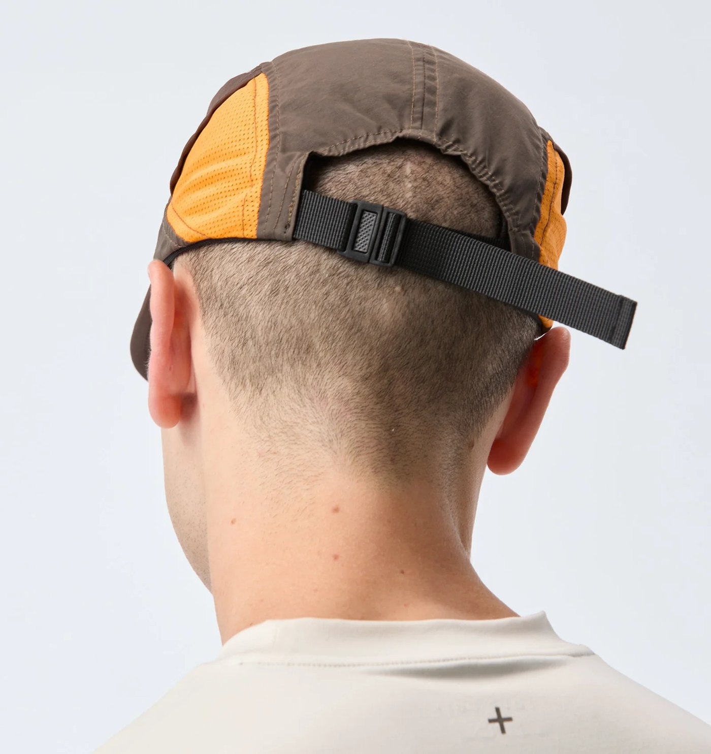 Back of the panelled cap showing the mesh panels and webbing strap with slider buckle