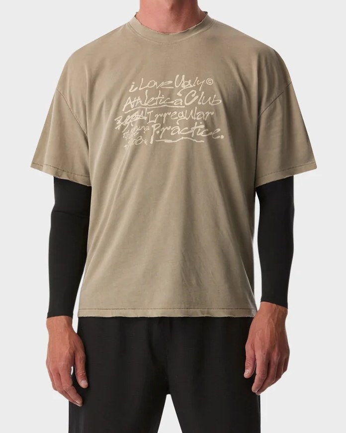 Washed sand cotton active crop tee with hand-drawn Athletica Club graphic, layered over a black long sleeve