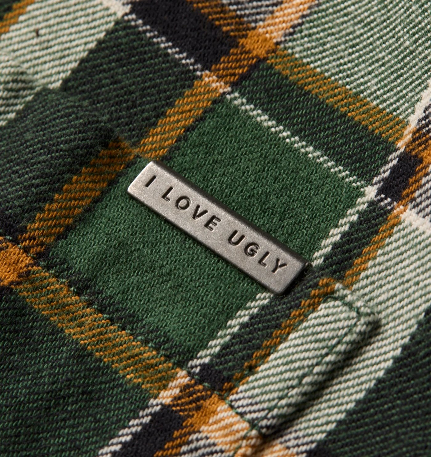 Close-up of the flannel twill weave and metal logo plate on the chest pocket