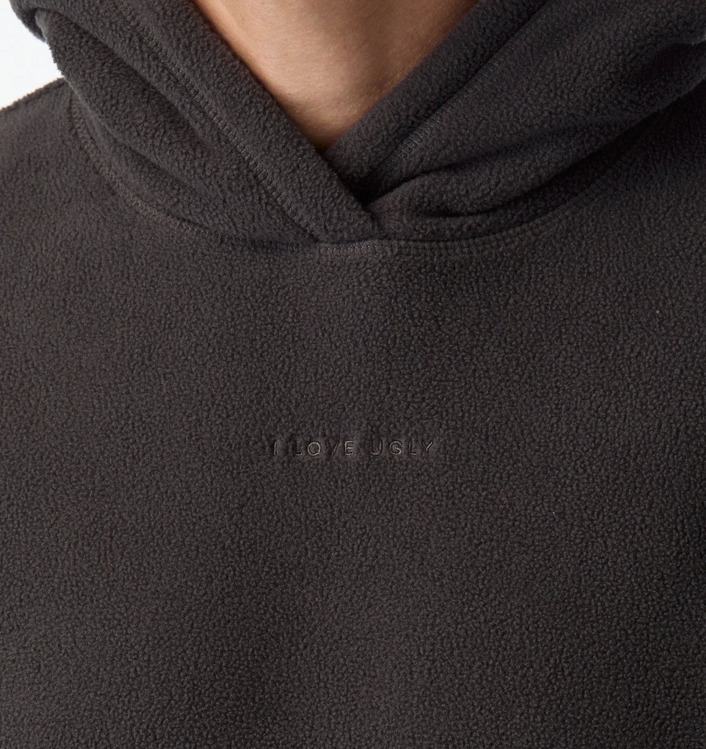 Close-up of the polar fleece texture and tonal embroidered wordmark below the hood