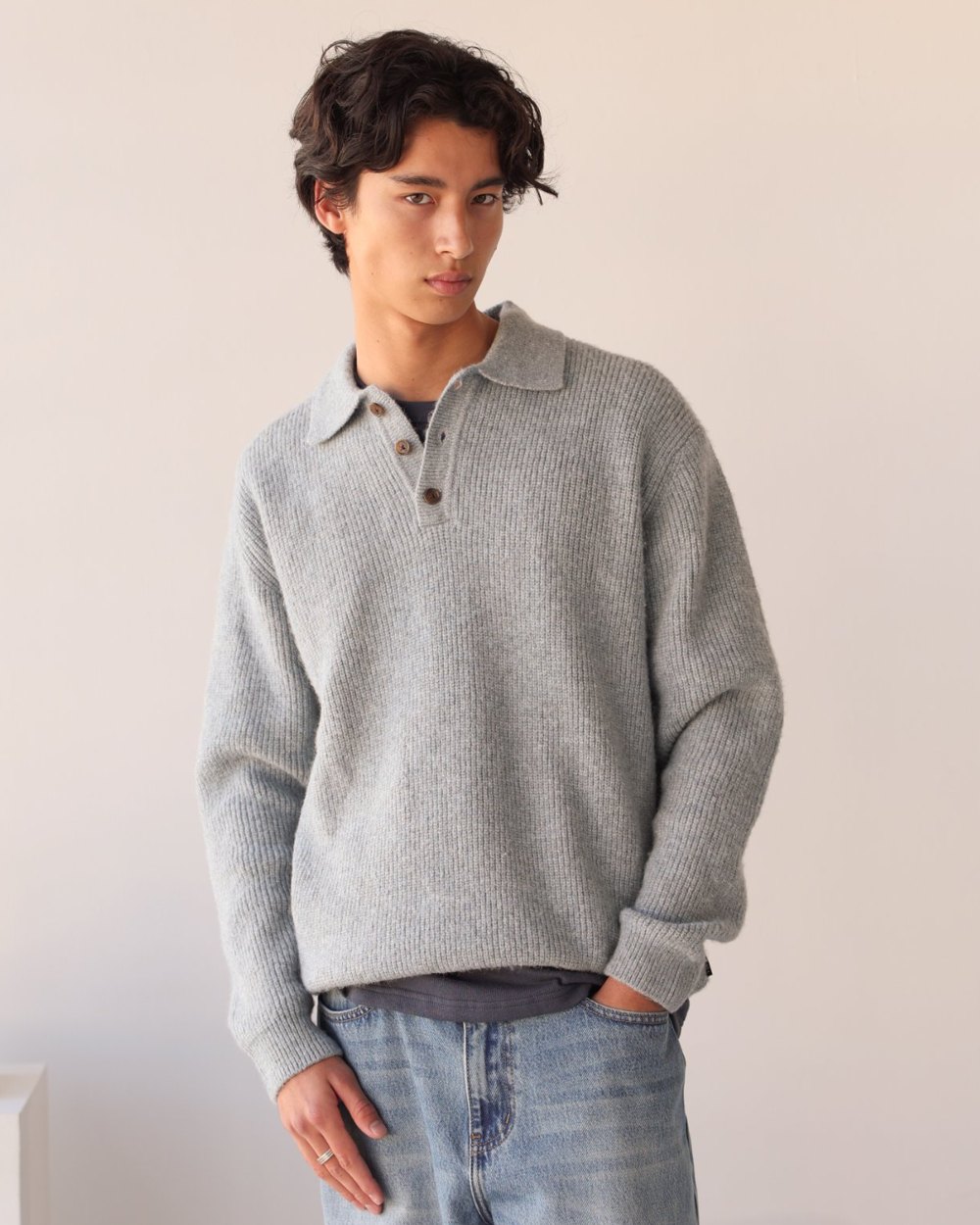 Grey marl brushed knit polo with three-button placket worn with light wash denim