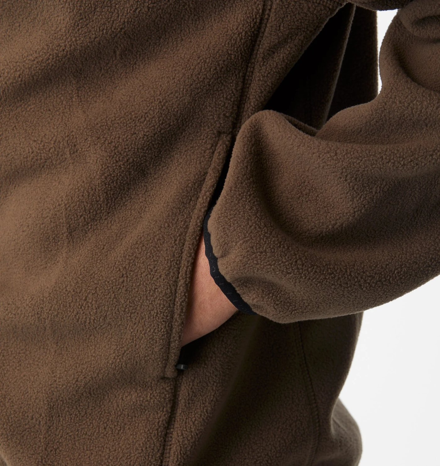 Close-up of the fleece texture, side pocket and branded binding at the cuff
