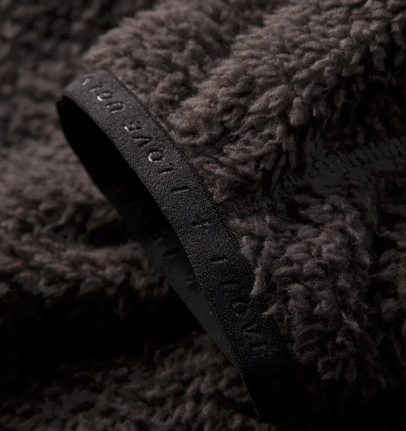 Close-up of the shaggy high-pile fleece and wordmark binding