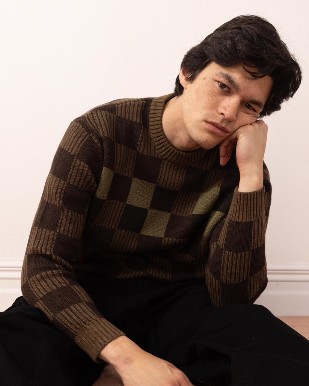 Seated shot of the checkerboard knit showing the ribbed and moss-stitch blocks