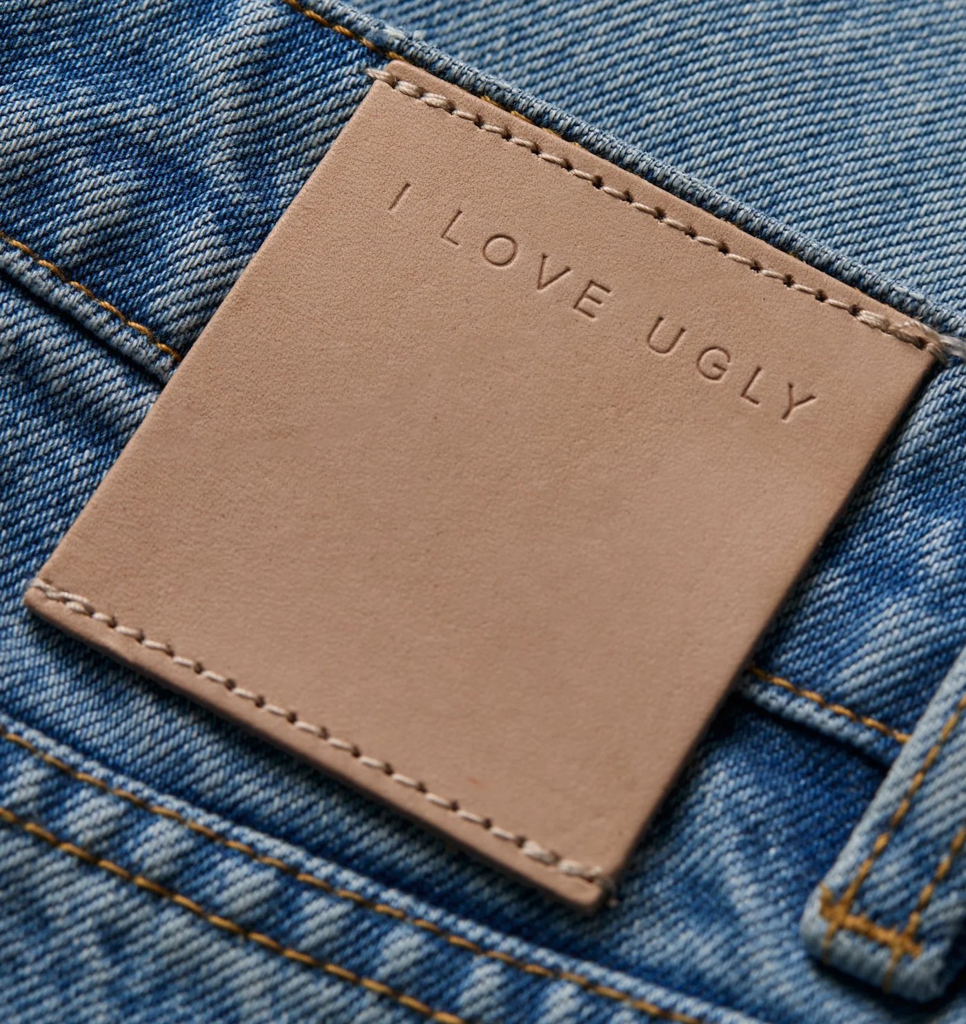 Close-up of the debossed leather back patch on the denim