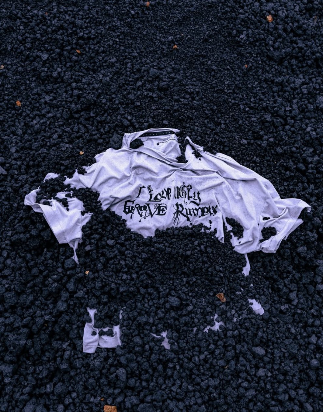White Grave Runners tee half buried in black volcanic scoria