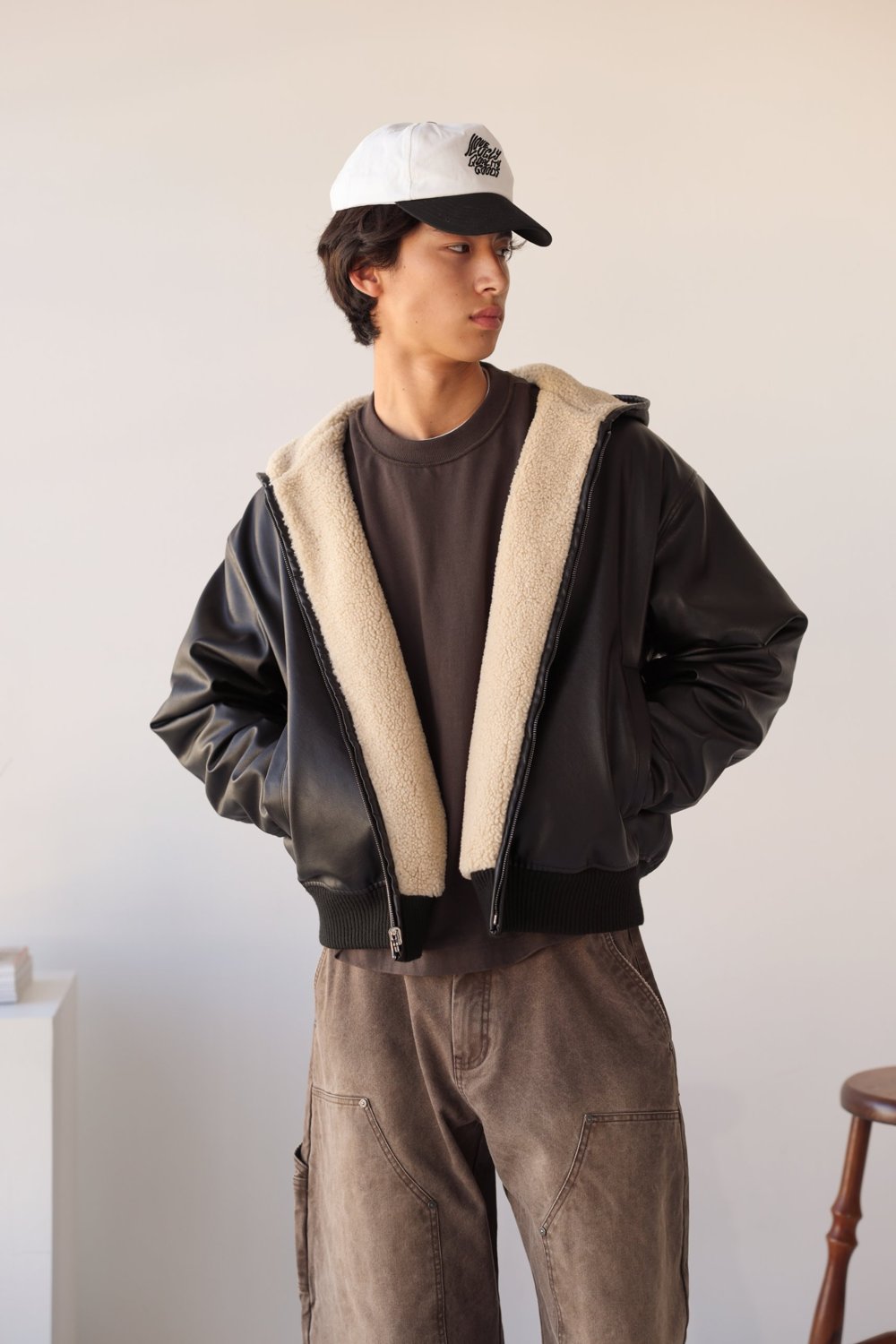 Black faux leather hood jacket with cream sherpa lining, worn open