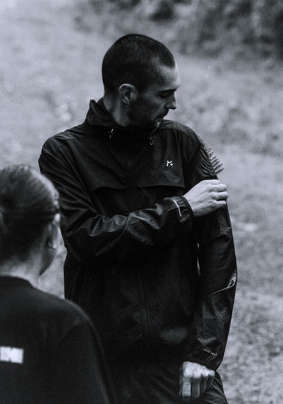 Black and white photo of a runner in the black hooded running jacket