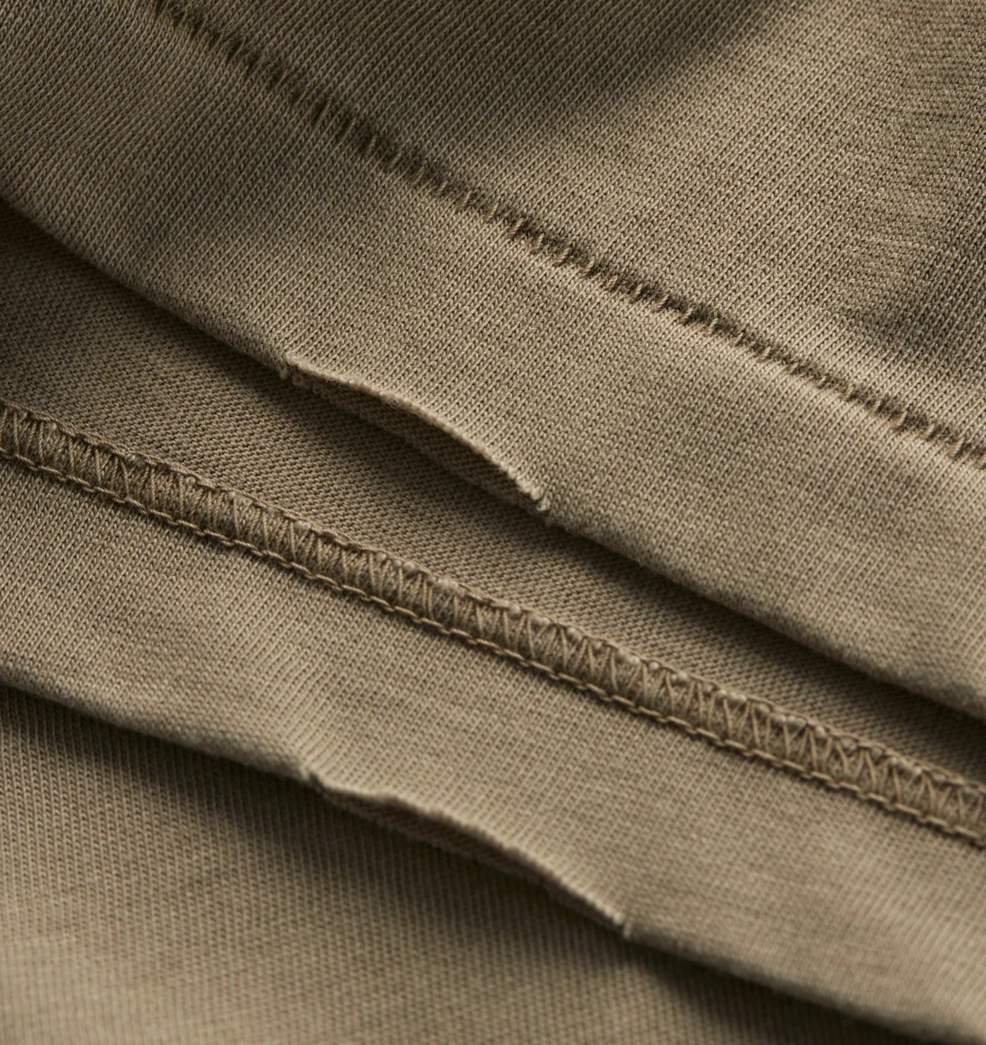 Close-up of the raw edge hem and coverstitch on the washed cotton